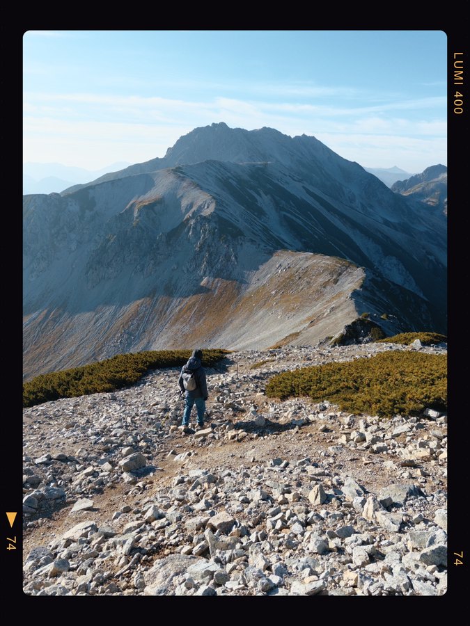 竖幅山脊样片：背包客面向层叠的山峰